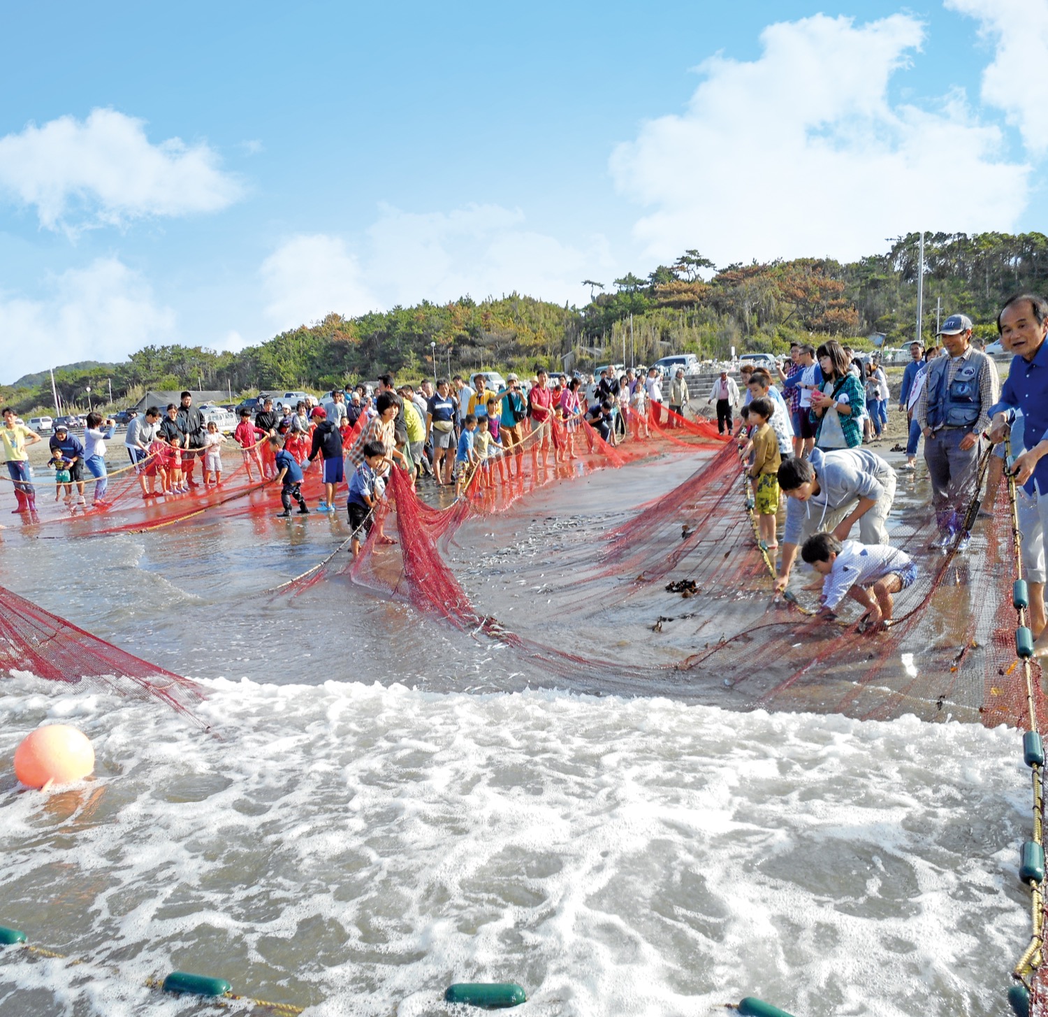 海辺で地引網を体験する参加者